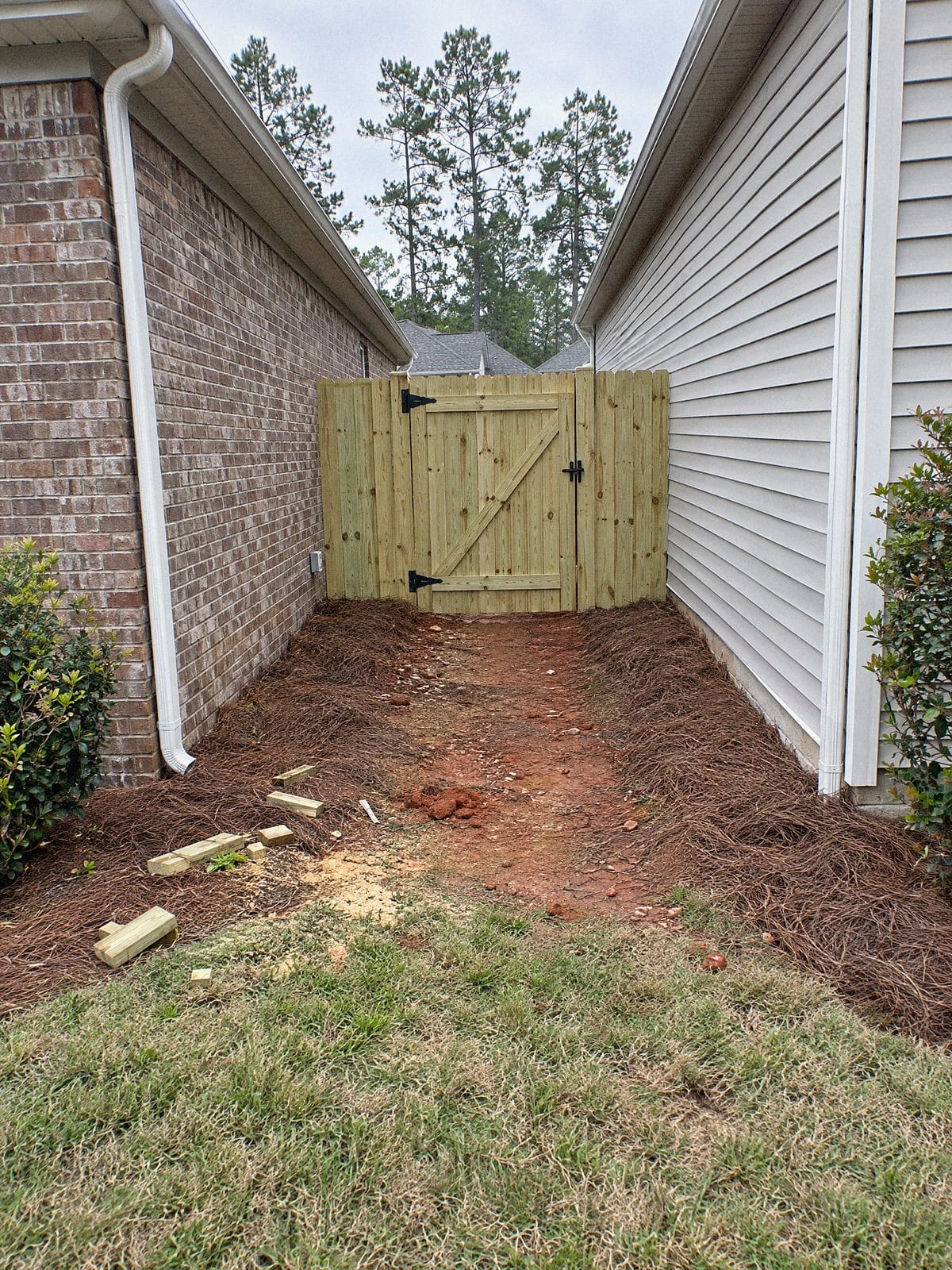 Wood privacy fence and walk gate closing off a side yard between two houses